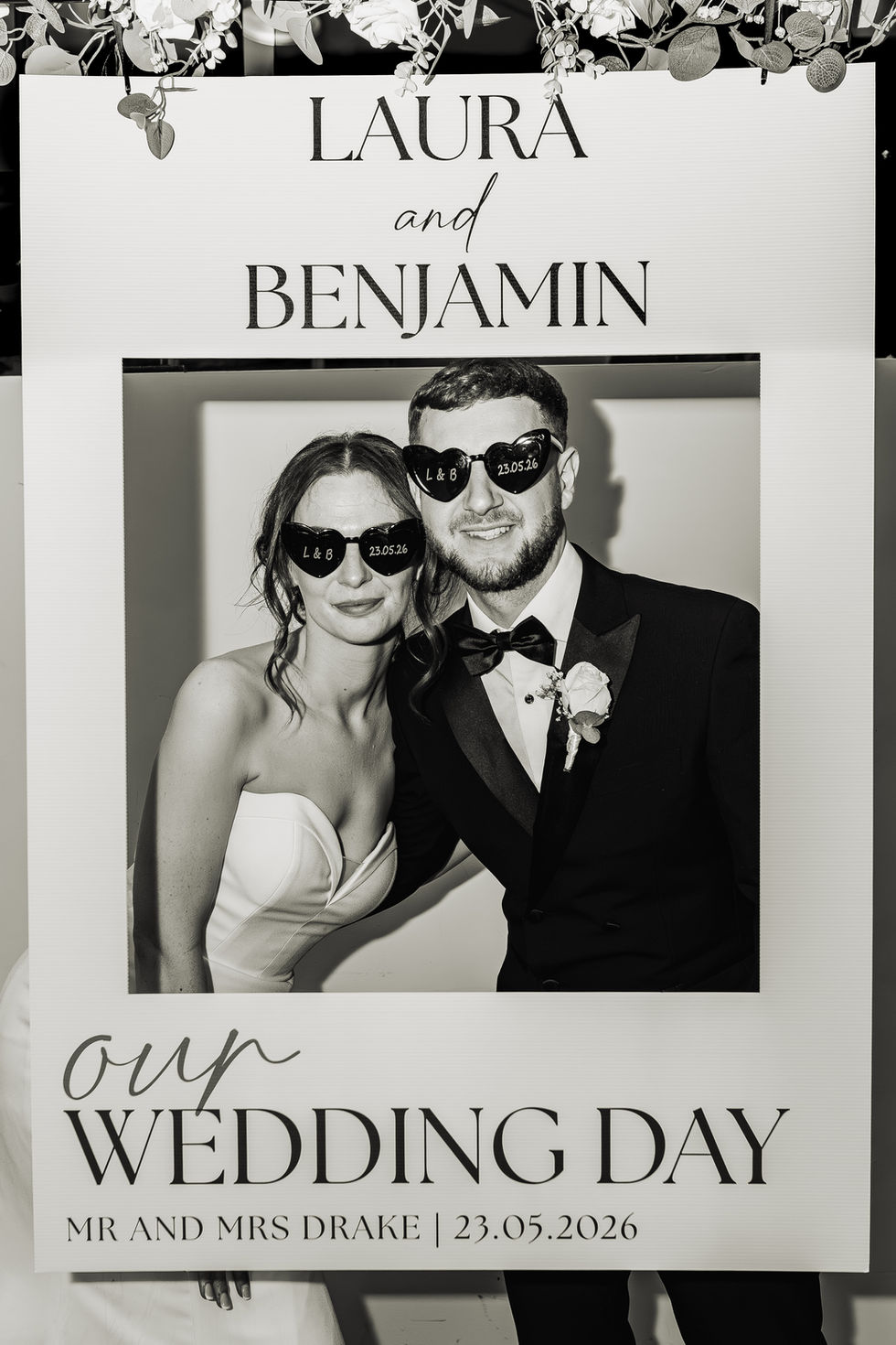 Couple wearing sunglasses at a wedding photo booth.
