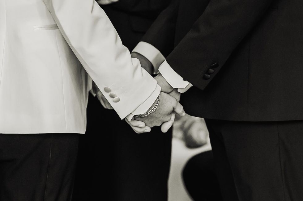 Two people holding hands, dressed in formal attire.