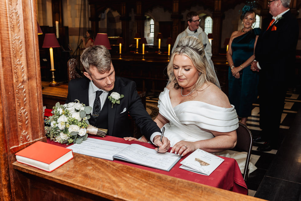 Bride and groom signing wedding documents in church.