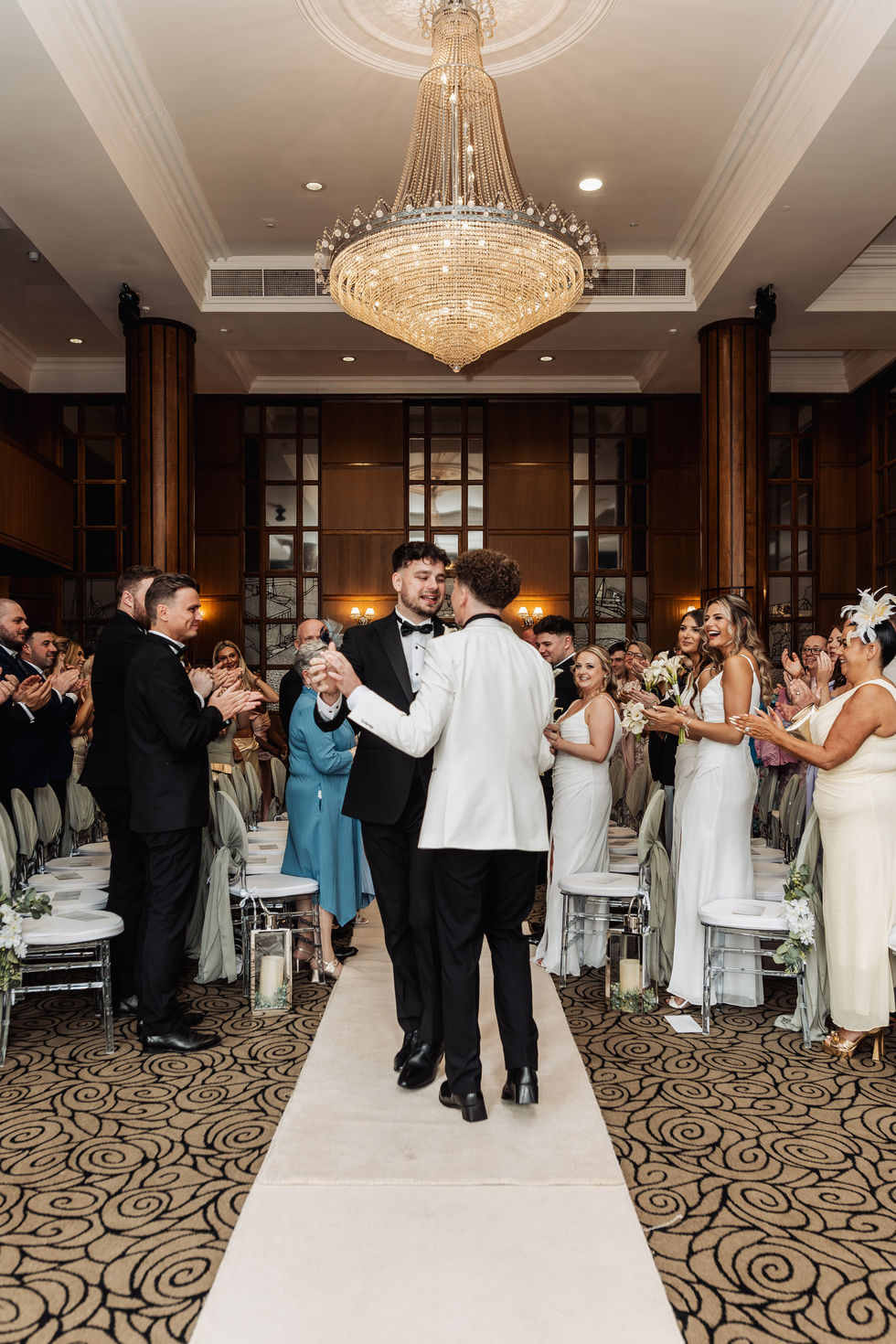 Elegant wedding ceremony with guests applauding.