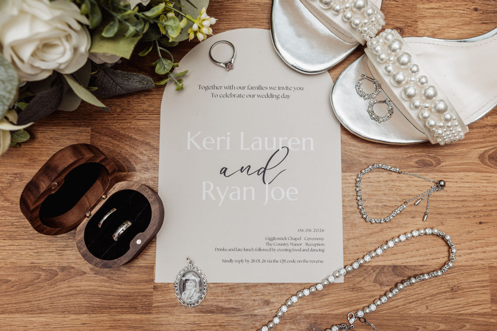 Wedding invitation with jewelry and flowers displayed.