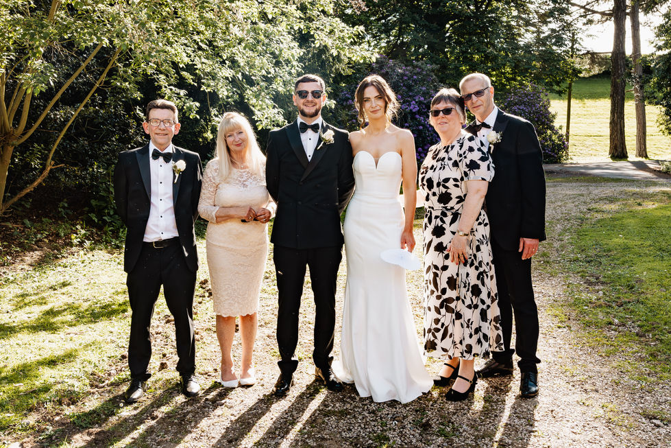 Group of people posing outdoors in formal attire.