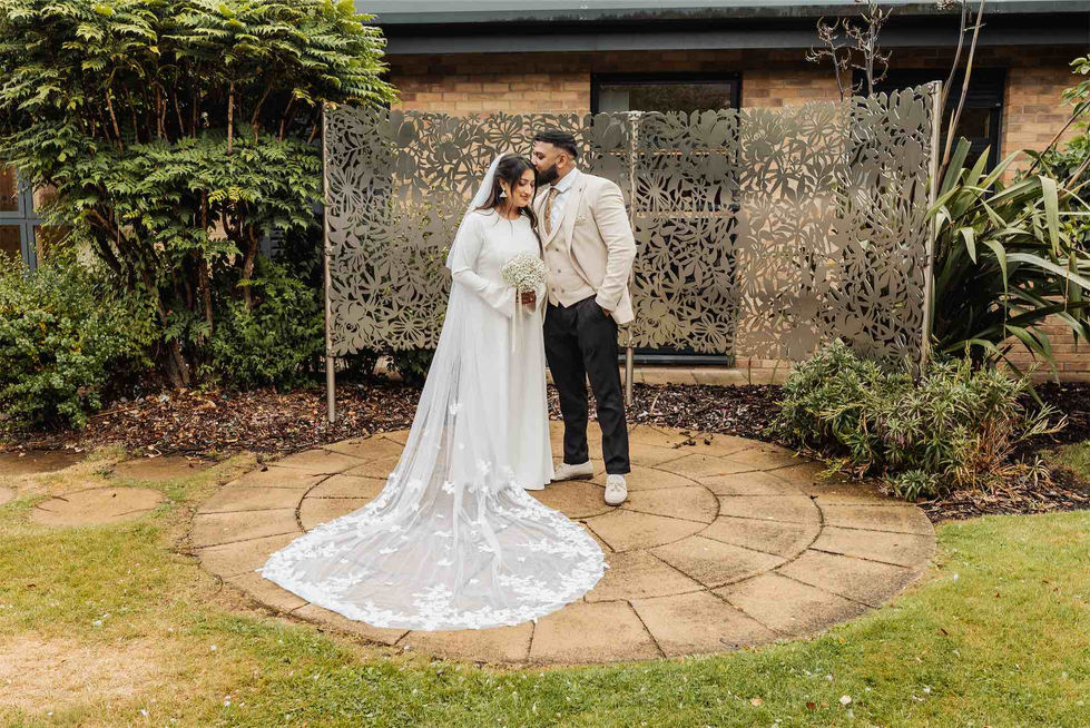 Bride and groom standing on circular stone path.