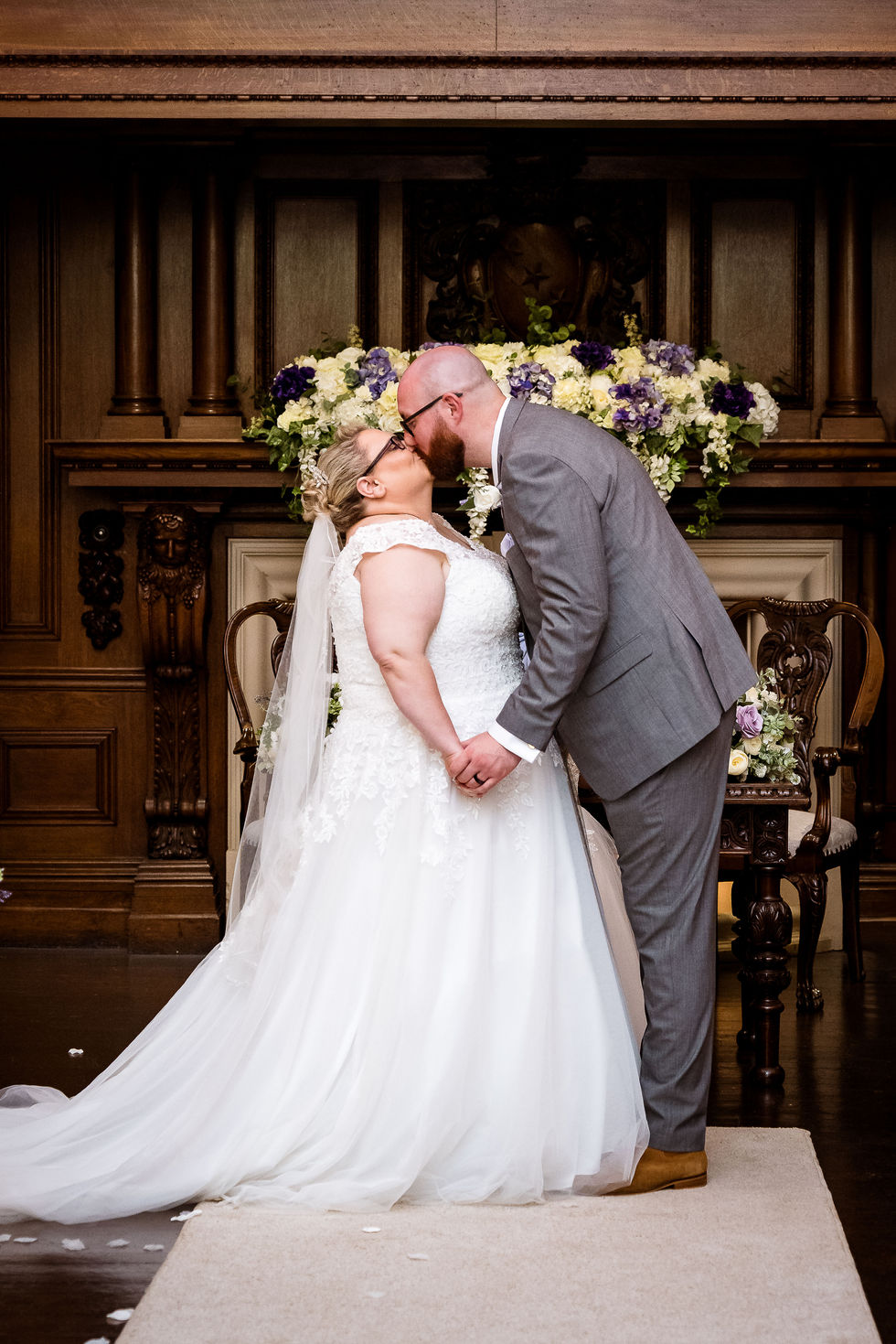 a bride and groom kissing in front of flowers