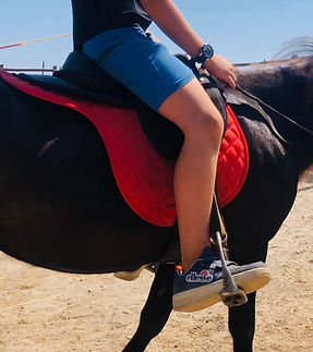 Kind auf einem schwarzen Shetlandpony von Sterpeti während einer Satteltaufe und ersten Reiterfahrungen