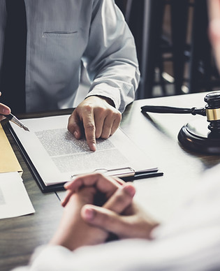 Universa Law- Judge's Table. Two men sat at table comparing notes.