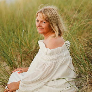Frau in der Düne, weißes Kleid von der Seite fotografiert 