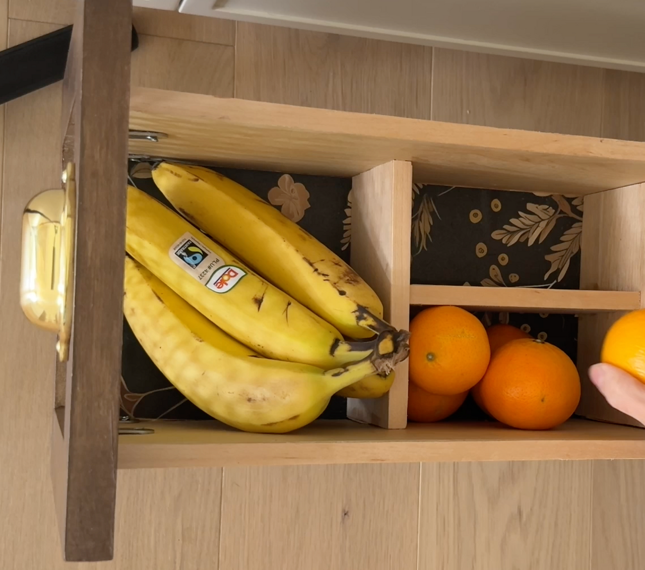 Open produce drawer organizing bananas and oranges