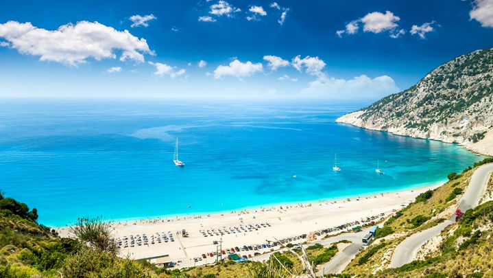 Aerial view of Myrtos Beach in Kefalonia with turquoise water, white pebbles and steep cliffs