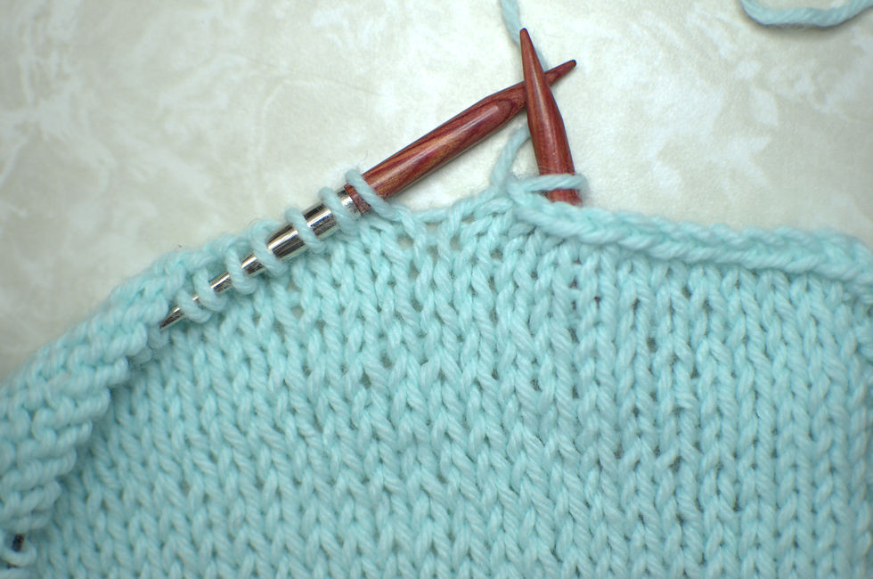 Light blue knitted fabric in the middle of a bind-off