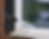 Close-up of pressure washing a white-framed window on a brick home with black shutters, removing dirt and grime.