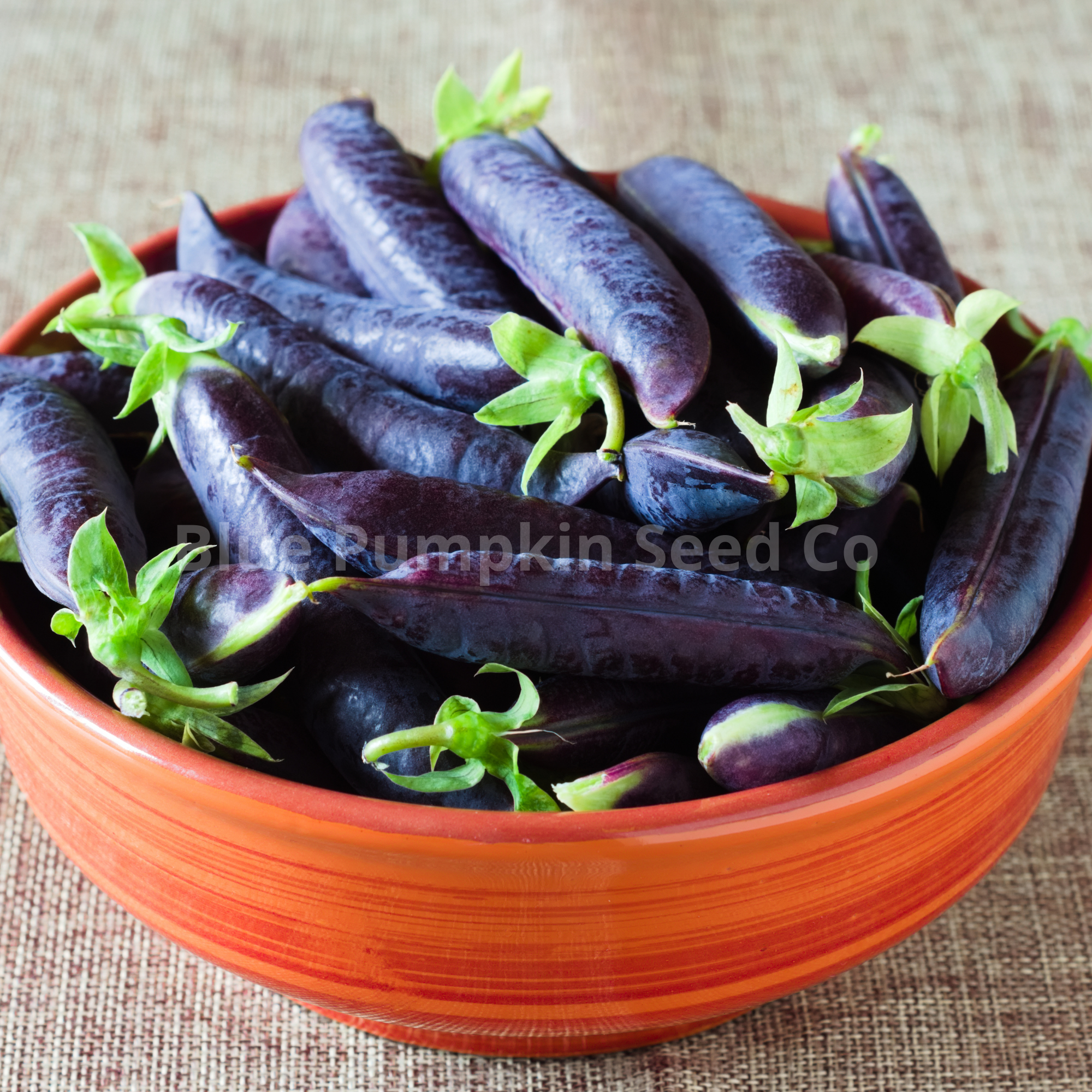 A wooden bowl of Sugar magnolia pea pods