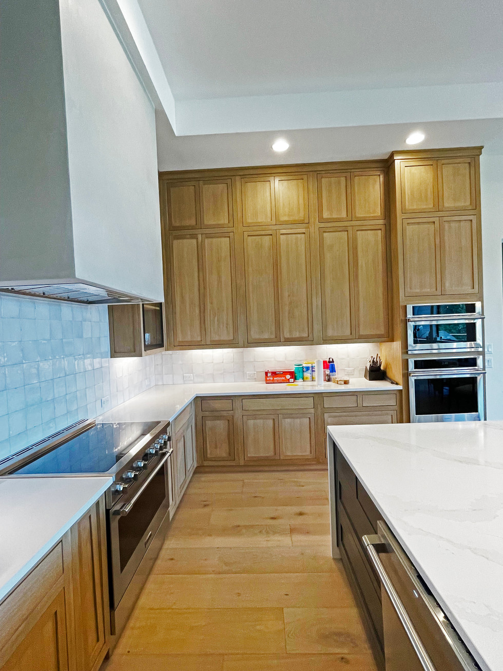White Oak custom cabinetry. Quartz countertops. Modern cement custom range hood. White oak flooring.