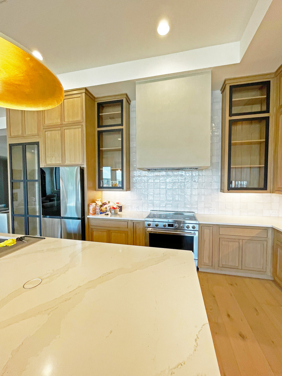Stove View of Custom Kitchen. Large square modern cement rangehood. Inset white oak cabinetry. black accents.