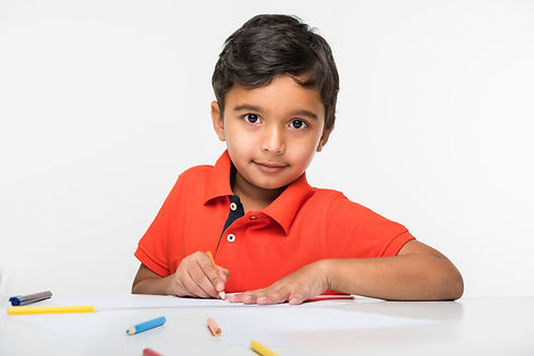 indian-boy-child-using-colourful-pencil-drawing-studying-with-globe-magnifying-glass-sitti