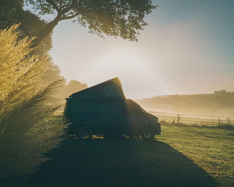 Campervan with roof popped up in the morning sunrise