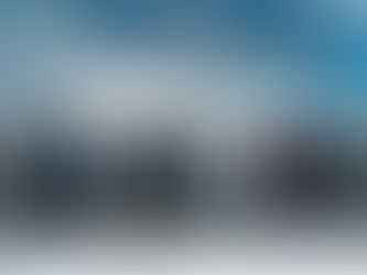 Three campervans parked up next to snowy mountain