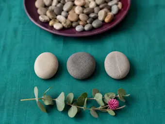 Three stones in a row apart from a pile of pebbles, one to three behaviour support plan strategies at a time.