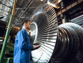 Technician checks on a turbine that is being serviced in a power generation plant.