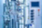Industrial bioreactor with numerous tubes, gauges, sensors, wires and other inputs and outputs connected.