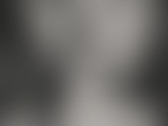 Grayscale close-up of a person holding a finger to their lips in a shushing gesture, suggesting silence and secrecy.