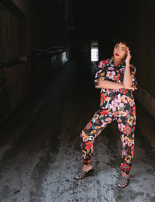 Female model posing in urban street scene wearing matching floral top and pants