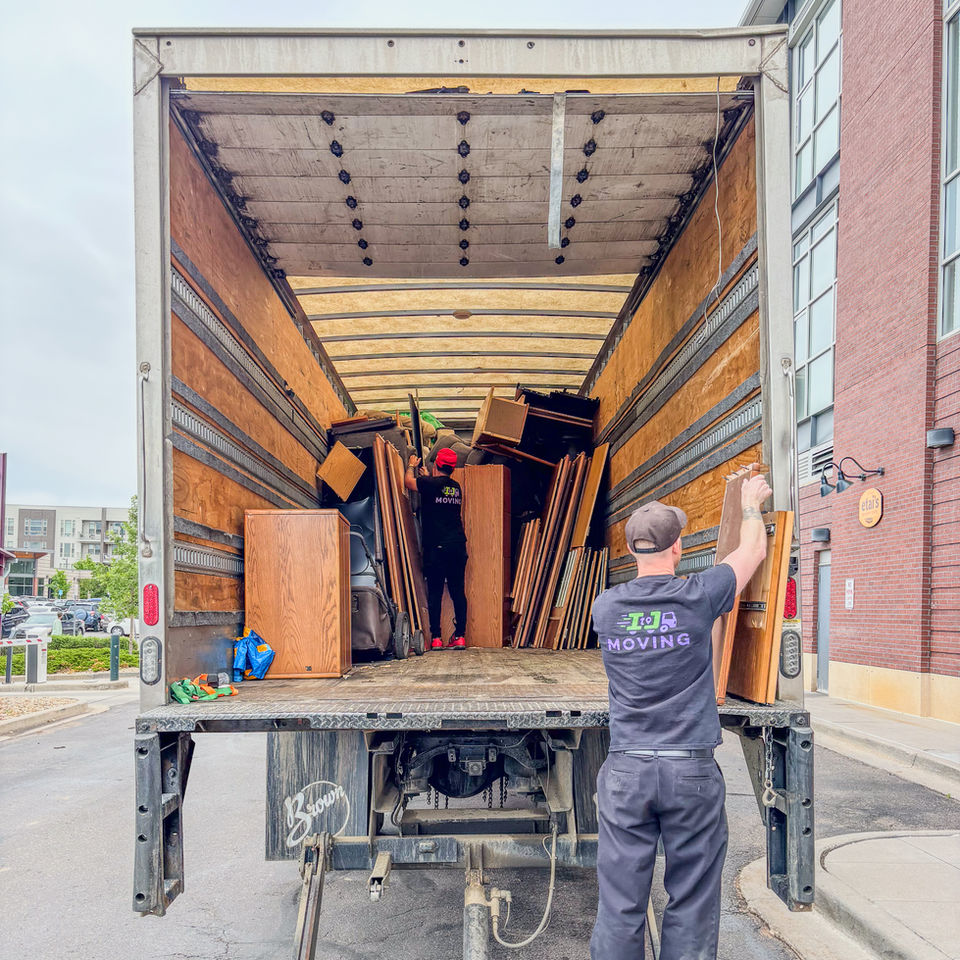 Two movers loading furniture into a moving truck