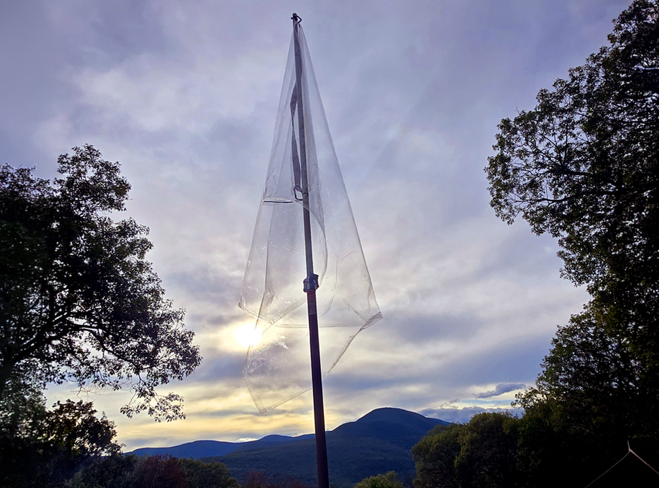 Transparent flag flies over a mountain range