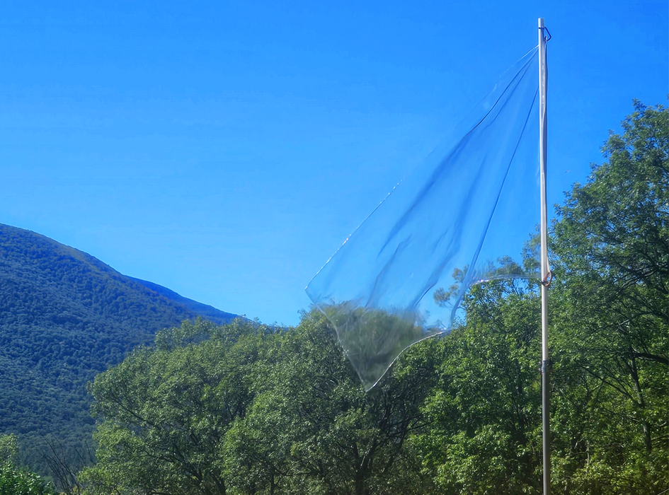 Transparent flag flies over a mountain range