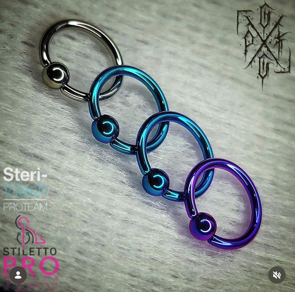 Anodized titanium captive bead rings in silver, blue, and purple finishes for professional body pier