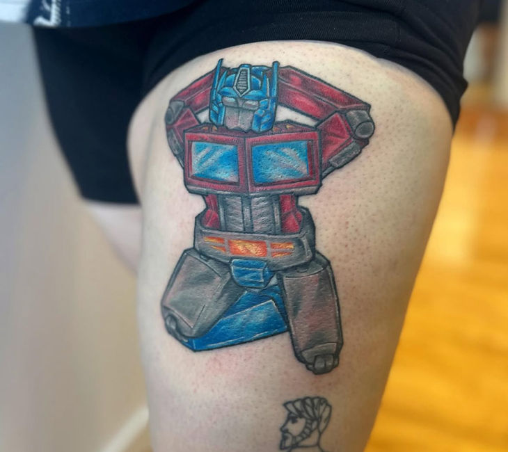 Illustrative Tattoo of Optimus Prime in a pinup pose. Illustrative Tattoo, Optimus Prime Tattoo, Transformers tattoo, nostalgic tattoo, pinup tattoo