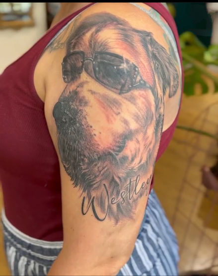 A beloved dog wearing sunglasses on a client's arm. Photo realism tattoo by Jodie Wentz in Winnipeg, MB Canada