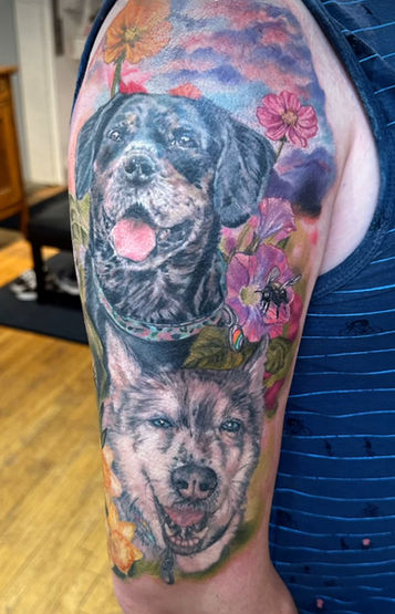 portraits of two beloved dogs; one black fur with brown muzzle, and one with husky colorings and markings. Pet Portrait Tattoos by Jodie Wentz in Winnipeg, MB Canada