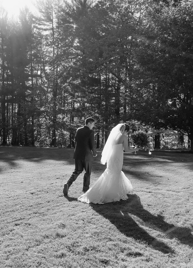 bride and groom walking on grounds of Stone House on the Hill