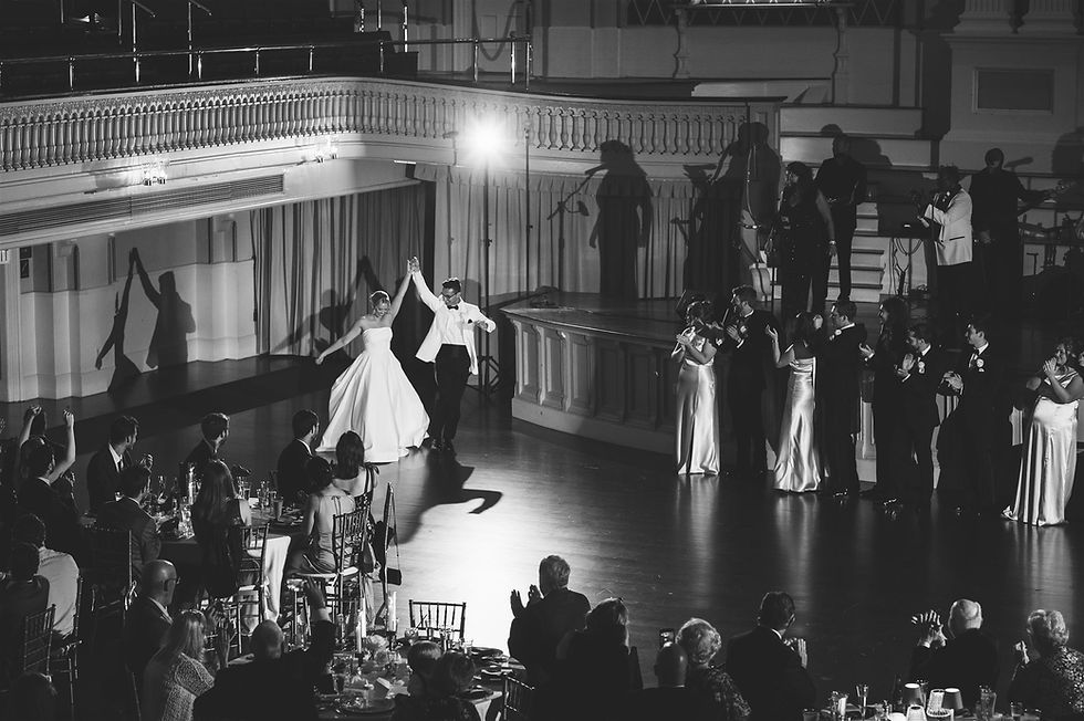 Bride and groom walking into their wedding reception holding hands
