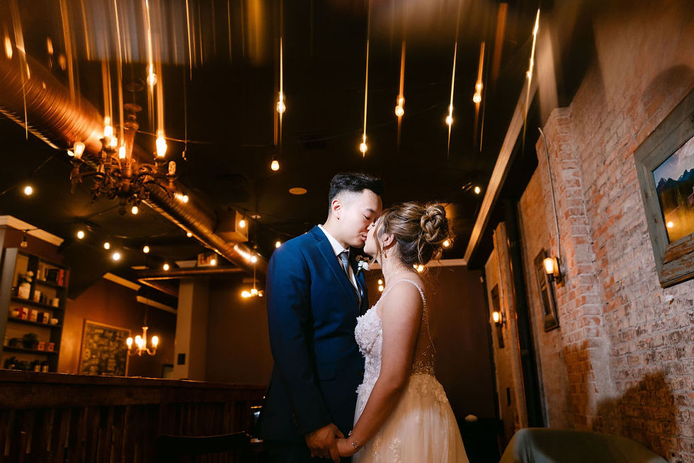 couple kissing in their wedding attires in a cafe