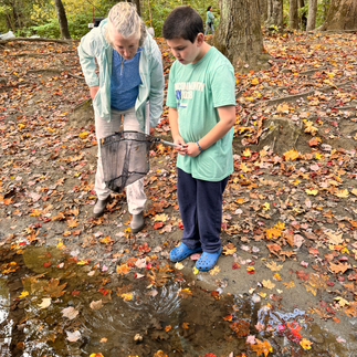 two people looking at something they found in a river