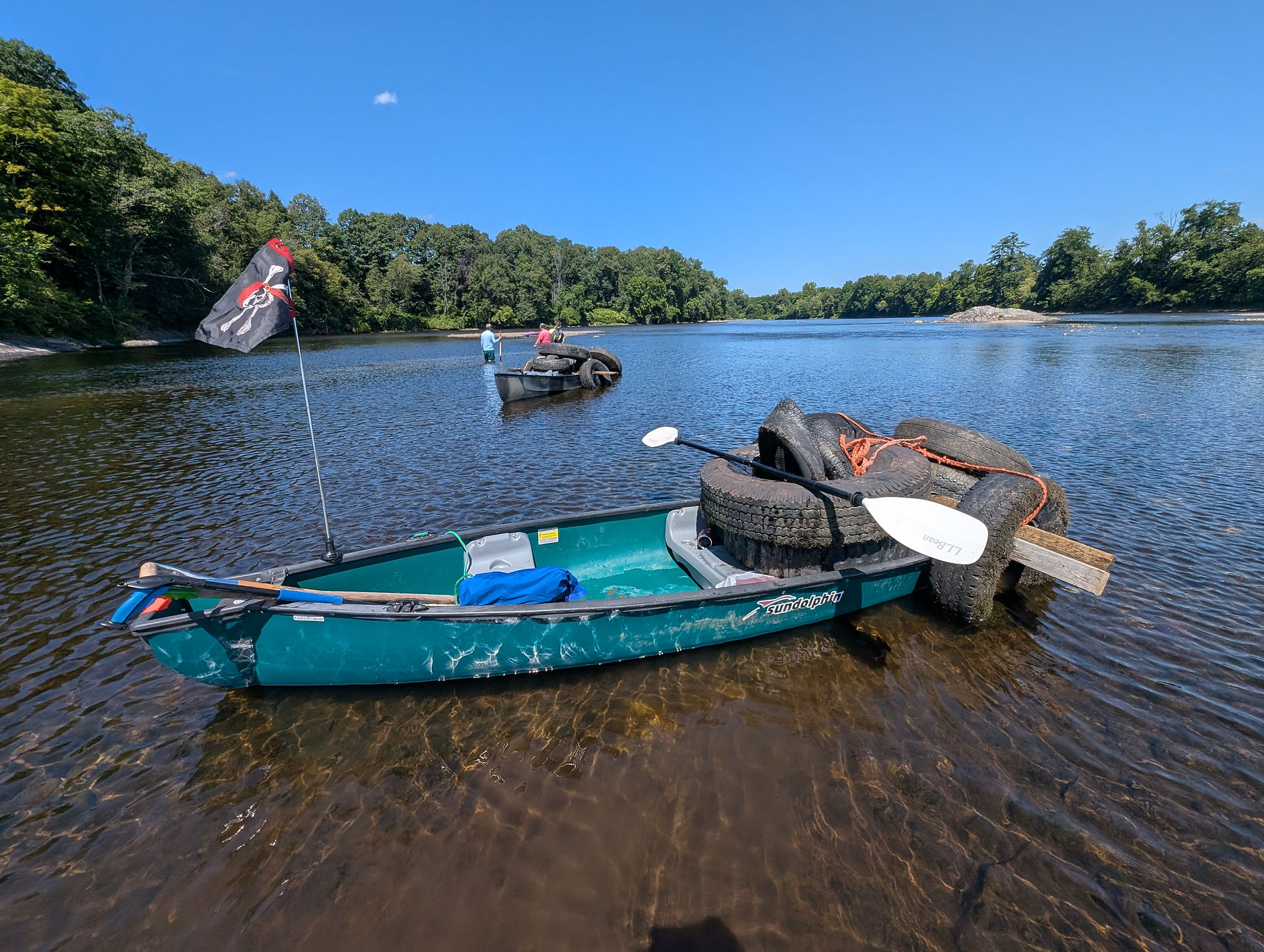 Canoe in river holding tires that volunteers recovered for the Source to Sea Cleanup.