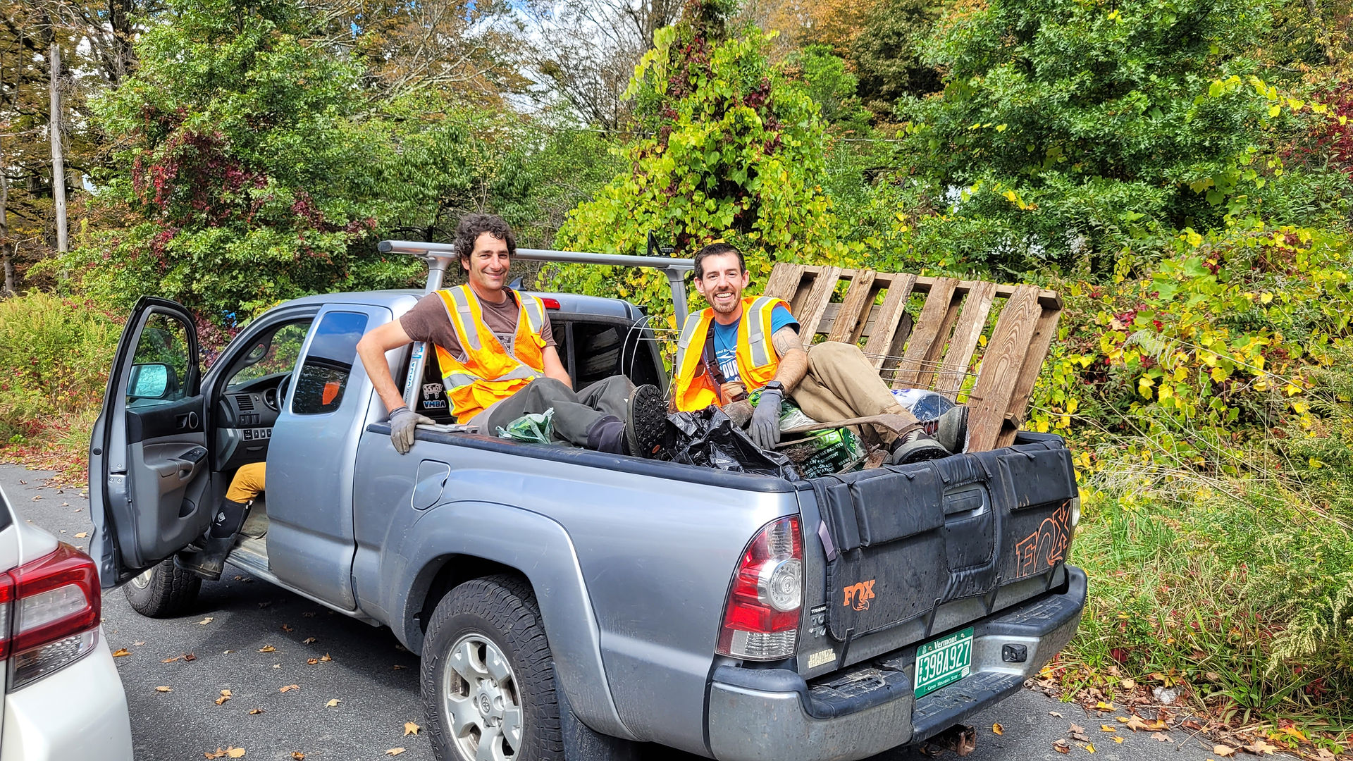 Volunteers pose on truck with trash