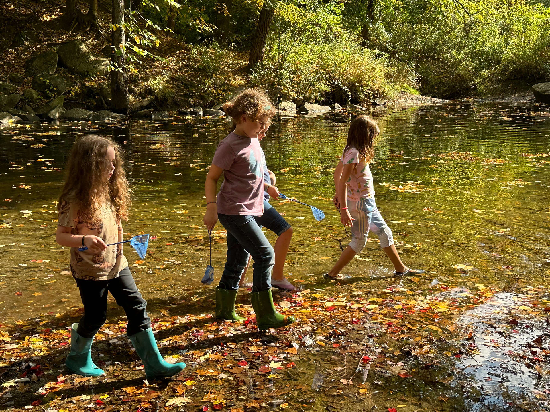 children walking with nets in a river