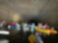 Kayaks going under a tunnel on a river