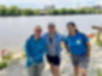 Three people posing on the side of a river