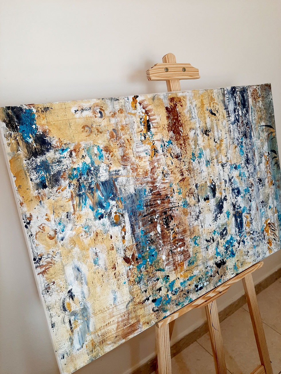 Thumbnail: Abstract art painting on an easel with yellow, blue, and brown tones.