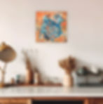 Abstract art with blue and orange colors displayed on the wall.
