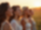 A diverse group of women in a soft, natural setting, sharing smiles and looking towards a