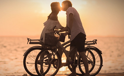 prenup agreemnt clients kissing on bikes at sunset