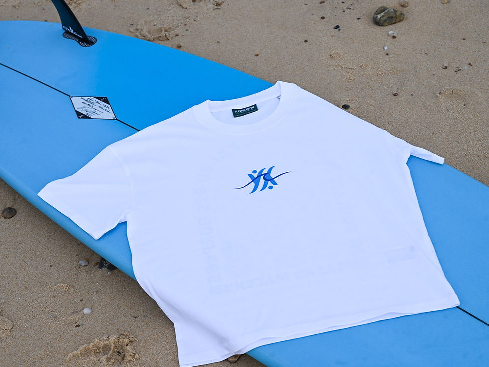 Miniature : T-shirt femme oversize blanc en coton bio Côte Ouest posé à plat sur une planche de surf, vue de face