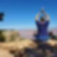 Debbie performing seated yoga pose on the edge of the Grand Canyon.