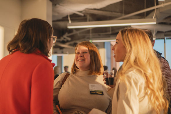3 women mingling and laughing at a rooftop corporate event at the Bank of America Plaza in Atlanta