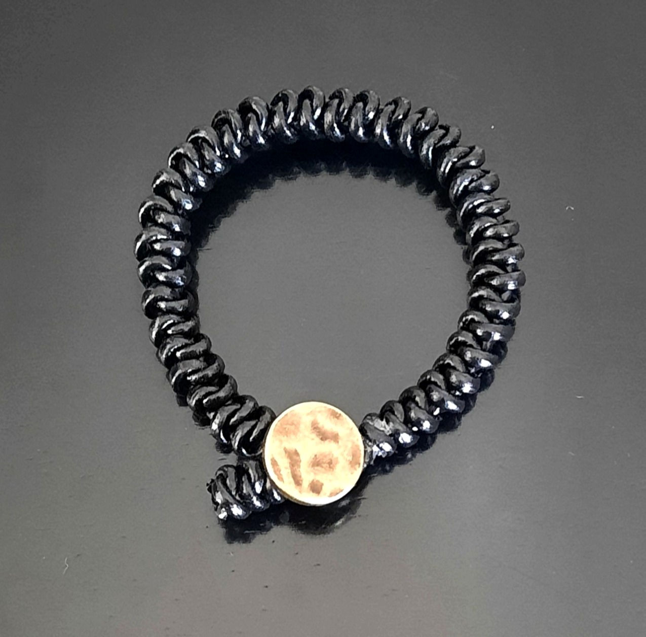 7.5" black genuine leather snake knot bracelet with an antique brass button closure.